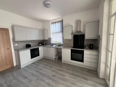 a large kitchen with white cabinets and a sink at Riverside by Teil in Preston