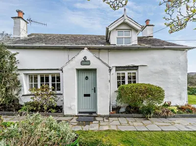 a white house with a green door at 3 Bed in Ulverston oc-91779 in Haverthwaite