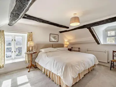 a bedroom with a large bed and two windows at 3 Bed in Ulverston oc-91779 in Haverthwaite