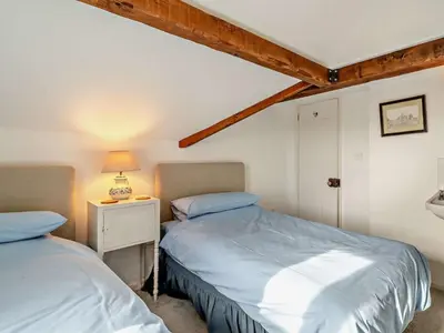 a bedroom with two beds and a table with a lamp at 3 Bed in Ulverston oc-91779 in Haverthwaite