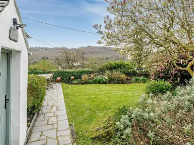 a garden with a stone walkway next to a house at 3 Bed in Ulverston oc-91779 in Haverthwaite