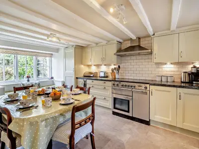 a kitchen with a table and chairs and a kitchen with white cabinets at 3 Bed in Ulverston oc-91779 in Haverthwaite