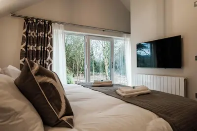 a bedroom with a large bed with two towels on it at Bramley Brook Cottage 5* Luxury in Whalley