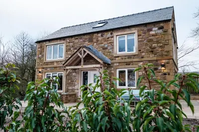 a stone house with a black roof at Bramley Brook Cottage 5* Luxury in Whalley