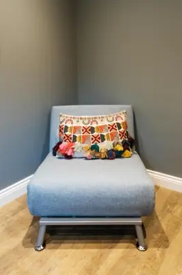 a blue chair with a pillow on top of it at Bramley Brook Cottage 5* Luxury in Whalley