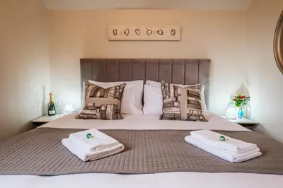 a bedroom with a bed with towels on it at Bramley Brook Cottage 5* Luxury in Whalley