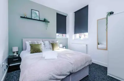 a bedroom with a large white bed with two windows at Spacious One-Bedroom Apartment in Saint Helens in Saint Helens