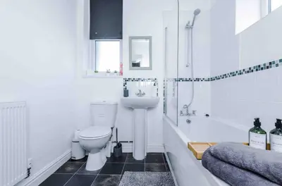 a bathroom with a toilet and a tub and a sink at Spacious One-Bedroom Apartment in Saint Helens in Saint Helens