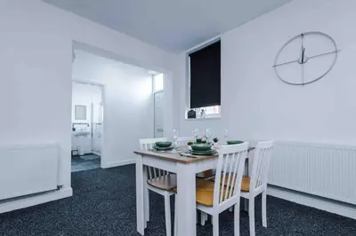 a white dining room with a white table and chairs at Spacious One-Bedroom Apartment in Saint Helens in Saint Helens