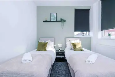two twin beds in a room with white walls at Spacious One-Bedroom Apartment in Saint Helens in Saint Helens