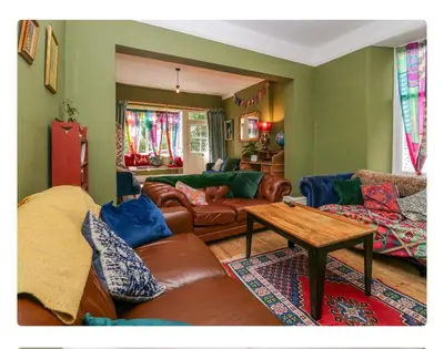 a living room with leather couches and a table at Sunnycote in Arnside