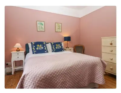 a bedroom with a large bed with blue pillows at Sunnycote in Arnside