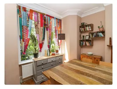 a room with a window with colorful curtains at Sunnycote in Arnside