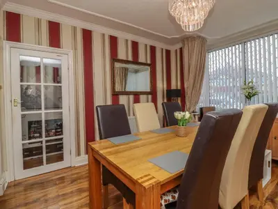 a dining room with a wooden table and chairs at 19 Slinger Road in Cleveleys