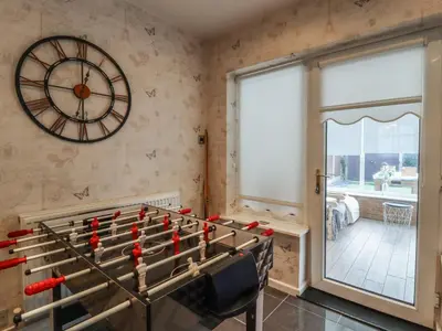 a room with a foosball table and a clock on the wall at 19 Slinger Road in Cleveleys