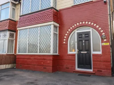 a red building with a black door and windows at 19 Slinger Road in Cleveleys