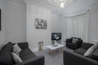 a living room with two couches and a table at Beautiful Family Home in Blackpool for you in Blackpool