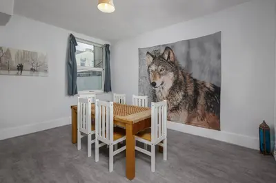 a dining room with a wolf painting on the wall at Beautiful Family Home in Blackpool for you in Blackpool