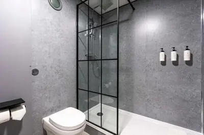 a bathroom with a shower and a toilet at The Bolton Stadium Hotel, a member of Radisson Individuals in Bolton