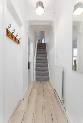 a hallway with white walls and a staircase with wooden floors at St Davids House - Air Host & Stay - 4 Bedrooms - Contractor Friendly in Liverpool