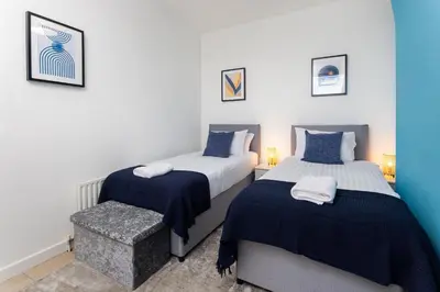 a bedroom with two beds with blue and white sheets at St Davids House - Air Host & Stay - 4 Bedrooms - Contractor Friendly in Liverpool