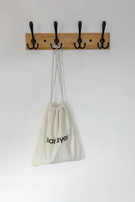 a white bag hanging on a wooden clipboard at Modern 2-Bed Townhouse in Kirkdale in Liverpool