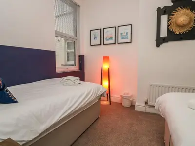 a bedroom with two twin beds and a lamp at West End Bay in Morecambe