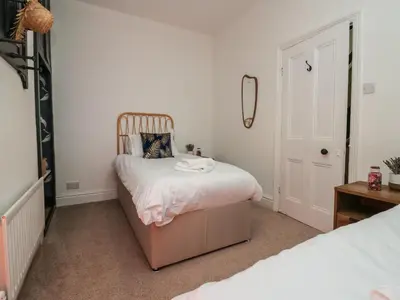 a small bedroom with a bed and a mirror at West End Bay in Morecambe