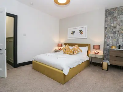 a bedroom with a bed and a nightstand with two lamps at West End Bay in Morecambe