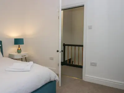 a bedroom with a bed and a door leading to a staircase at West End Bay in Morecambe
