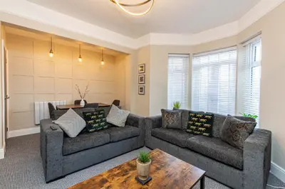 a living room with two couches and a table at Beachfront Apartment 3 Bedrooms Sleeps 7 - Gateway to the Lake District - Newly Refurbished in Morecambe