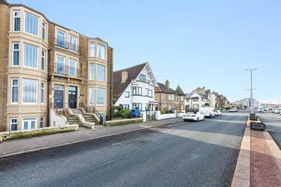 a city street with houses and cars parked on the street at Beachfront Apartment 3 Bedrooms Sleeps 7 - Gateway to the Lake District - Newly Refurbished in Morecambe