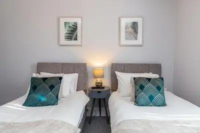 two beds sitting next to each other in a room at Beachfront Apartment 3 Bedrooms Sleeps 7 - Gateway to the Lake District - Newly Refurbished in Morecambe