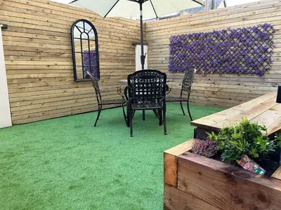 a patio with a table and chairs and an umbrella at Beachfront Apartment 3 Bedrooms Sleeps 7 - Gateway to the Lake District - Newly Refurbished in Morecambe