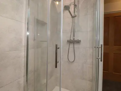 a shower stall with a glass shower door at Old Watermill in Grange Over Sands
