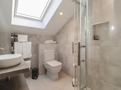 a bathroom with a toilet and a sink and a shower at Old Watermill in Grange Over Sands