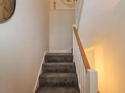 a staircase in a house with a clock on the wall at Old Watermill in Grange Over Sands