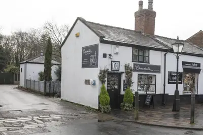 a white building on the corner of a street at Botanic Mews in Southport
