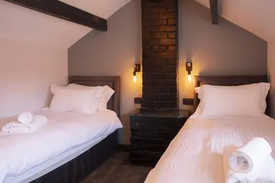 two beds in a room with white towels at Botanic Mews in Southport