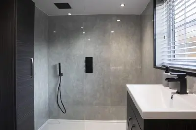 a bathroom with a shower with a glass door at Botanic Mews in Southport