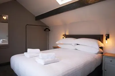 a bedroom with a large white bed with towels on it at Botanic Mews in Southport