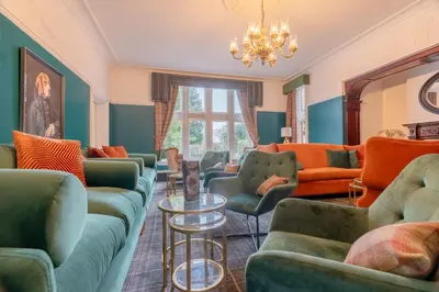 a living room with green and orange furniture at Springbank Manor in Darwen
