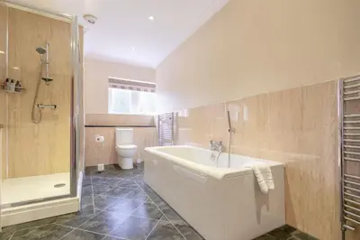a bathroom with a tub and a toilet and a sink at Springbank Manor in Darwen