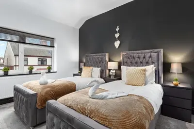 a bedroom with two beds and a large window at Luxury by the Sea, Beautiful 3 bedroom House with Fast WiFi, King Bed, Lovely Garden! Blackpool's Finest Getaway Experience for up to 8 Guests! in Blackpool