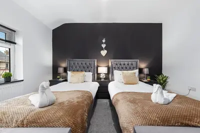 a bedroom with two beds with white pillows at Luxury by the Sea, Beautiful 3 bedroom House with Fast WiFi, King Bed, Lovely Garden! Blackpool's Finest Getaway Experience for up to 8 Guests! in Blackpool