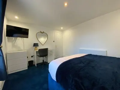 a bedroom with a bed and a desk and a mirror at AQUARIUS APARTMENT - SEA VIEW - SLEEPS SEVEN in Blackpool