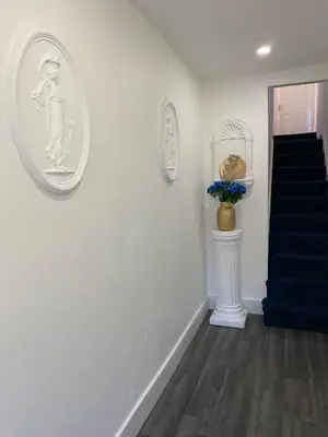 a hallway with white walls and a blue staircase at AQUARIUS APARTMENT - SEA VIEW - SLEEPS SEVEN in Blackpool