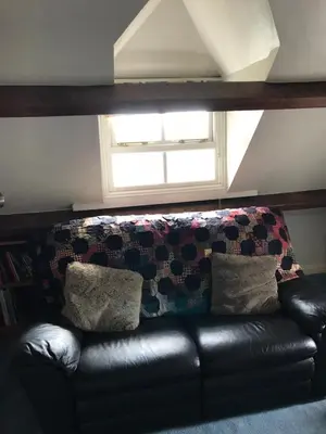 a black leather couch in a room with a window at st marys mount in Ulverston
