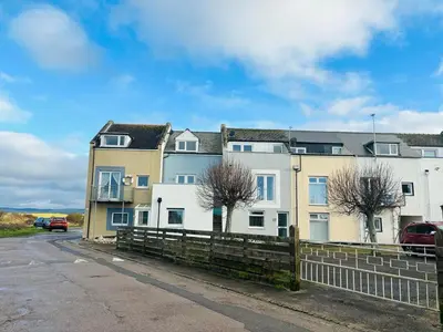 a large building with a fence in front of it at 23 Coastal Comfort in Millom