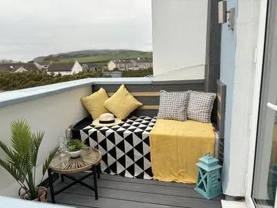 a balcony with a bed and pillows on it at 23 Coastal Comfort in Millom